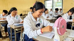扇風機を使って涼む女子生徒＝２日、カンボジア